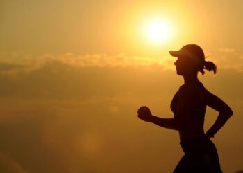 woman with white sunvisor running